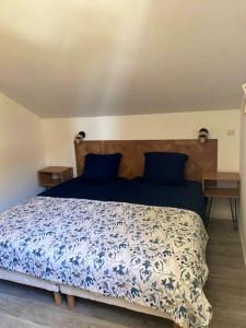 a bedroom with a blue and white bed and two night stands at Chalet de 3 chambres a Le Devoluy a 200 m des pistes avec piscine partagee sauna et terrasse in Le Dévoluy