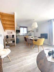 a living room with a table and a dining room at Chalet de 3 chambres a Le Devoluy a 200 m des pistes avec piscine partagee sauna et terrasse in Le Dévoluy