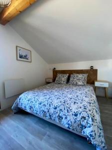 a bedroom with a bed with a blue and white bedspread at Chalet de 3 chambres a Le Devoluy a 200 m des pistes avec piscine partagee sauna et terrasse in Le Dévoluy