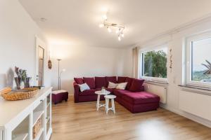 a living room with a red couch and a table at Ferienwohnung Grübel in Kirchhundem