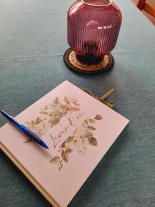 a greeting card and a pen on top of a table at Gîte Le Sambre in Thuin