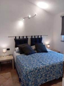 Schlafzimmer mit einem Bett mit blauer Decke in der Unterkunft La Tana del Berü in Varraze
