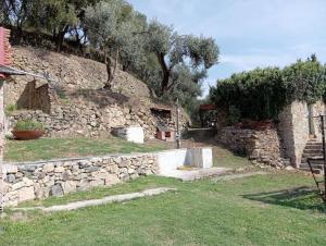 ein Steingebäude mit einer Steinmauer und Bäumen in der Unterkunft La Tana del Berü in Varraze