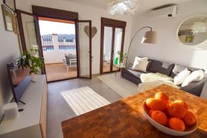 a bowl of oranges on a table in a living room at Casita Frigiliana - stunning new apartment with views with private parking space in Frigiliana