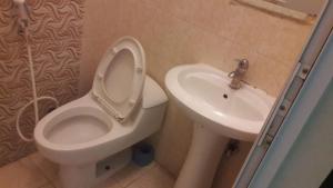 a bathroom with a toilet and a sink at كوتاج المفروشة in Al Khobar