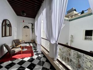 a room with a balcony with a table and chairs at Riad Tizwa Marrakech in Marrakech