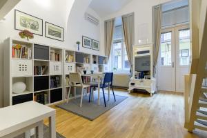 Cette chambre comprend une table, des chaises et une étagère à livres. dans l'établissement Main Square Studio Mare, à Zagreb