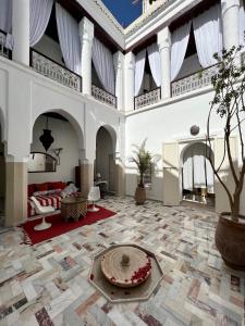 a large room with a living room with a fireplace at Riad Tizwa Marrakech in Marrakech