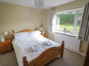 Un dormitorio con una cama grande y una ventana. en The Highlands, en Church Stretton