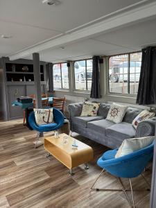 a living room with a couch and chairs and a table at Gîte Le Sambre in Thuin