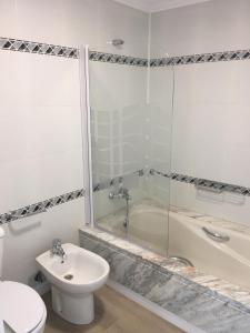 a bathroom with a toilet and a tub and a sink at Sands Beach - Hoy Hotels in Costa Teguise