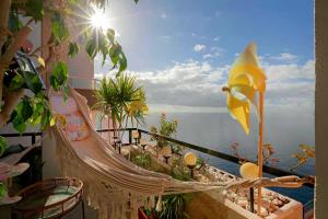 een hangmat op een balkon met uitzicht op de oceaan bij Luxury House Direct To The Beach & Natural Salt Pool in Tabaiba