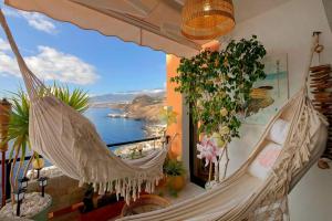een hangmat in een kamer met uitzicht op het water bij Luxury House Direct To The Beach & Natural Salt Pool in Tabaiba