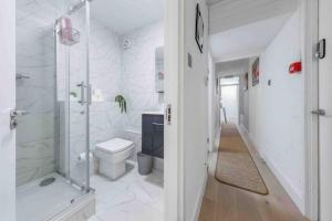 y baño blanco con ducha y aseo. en Luxury Sleep 10 Next to king cross SP7 en Londres