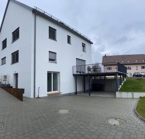 Edificio blanco con balcón y patio en Ferienhaus De Luxe en Engen