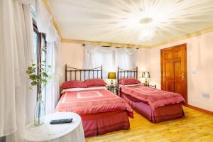 a bedroom with two beds with red comforter at Dunleath House in Downpatrick