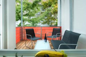 3 sillas y una mesa en un porche con en Ferienwohnung Hafenglück 13 en Überlingen