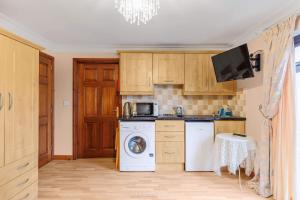 a kitchen with a washing machine and a washer at Dunleath House in Downpatrick