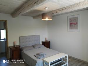 une chambre avec un lit blanc et une table dans l'établissement Le Mas des Calus Chambres d'hôtes, à LʼIsle-sur-la-Sorgue 16 autres photos