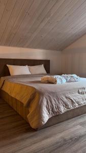 a bedroom with a large bed with a wooden ceiling at Nicolas Resort Club in Kyiv