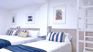 2 camas en una habitación con paredes blancas en A Marisma Hostal, en Redondela