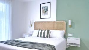 1 dormitorio con 1 cama grande con sábanas blancas en A Marisma Hostal, en Redondela