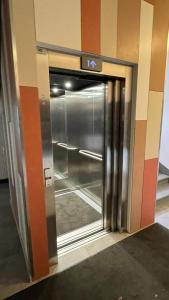 an elevator door in a building with a sign on it at Hugo apartment & parking in Rīga