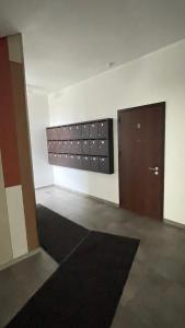 een kamer met een deur en een muur met een tapijt bij Hugo apartment & parking in Rīga