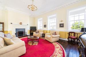 a living room with couches and a red rug at Stunning & spacious Georgian town house in St Neots town centre with parking in Saint Neots