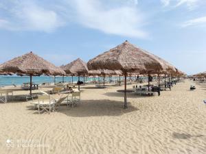 una spiaggia con molti ombrelloni e tavoli di paglia e sedie di Bridge's House - a 50 mt dalla spiaggia e da tutti i servizi! a Pescara