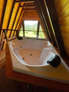eine Badewanne in einem Zimmer mit Fenster in der Unterkunft Cabana Montana in Picada Cafe