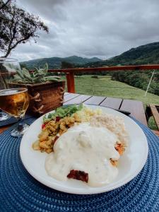 einen Teller mit Essen auf einem Tisch mit einem Glas Wein in der Unterkunft Cabana Montana in Picada Cafe