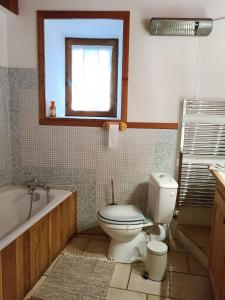 La salle de bains est pourvue de toilettes, d'une baignoire et d'une fenêtre. dans l'établissement Landrosace, au Monêtier-les-Bains
