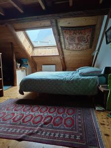 a bedroom with two beds and a rug in a attic at Landrosace in Le Monêtier-les-Bains