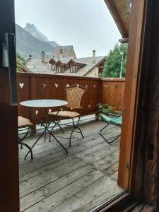 a patio with a table and chairs on a deck at Landrosace in Le Monêtier-les-Bains