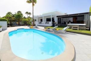 a swimming pool in front of a house at Casa Nublo - 3 Bedroom family villa - Great sea views from rooftop terrace in Puerto Calero