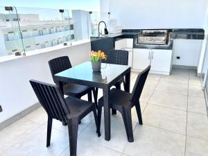 een eettafel en stoelen in een keuken bij Suite 1ra Fila Vista Bahía - 100 Metros Las Velas 601 T1 in Paracas