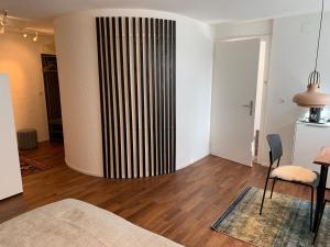 a living room with a striped wall and a table at B&B Biel-Brügg in Brügg