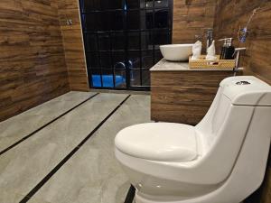 a bathroom with a white toilet and a sink at Covanro Sigiriya - Brand New Luxury Hotel in Sigiriya
