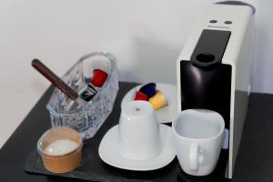 a black table with a white blender and a cup at 2 0 HÔTEL Vanille in Dzaoudzi