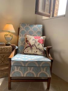 a chair with a pillow and a lamp on a table at Casa di Carolina Italian Holiday Home in Pacentro