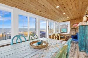 a dining room with a table and chairs and the ocean at White Horse Beach House: Plymouth in Plymouth