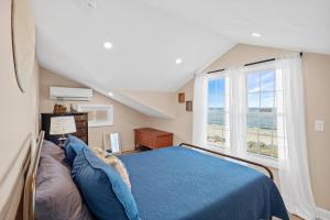 a bedroom with a blue bed and a large window at White Horse Beach House: Plymouth in Plymouth