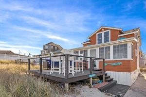 una casa con una terraza con sillas. en White Horse Beach House: Plymouth, en Plymouth