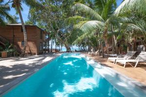 a swimming pool with palm trees and a resort at Arca in Roatan