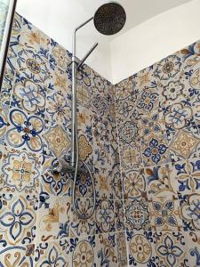 uma casa de banho com um chuveiro com azulejos azuis e brancos em Casa di Carolina Italian Holiday Home em Pacentro