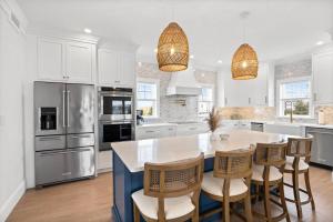 a kitchen with white cabinets and a table and chairs at Sandy Clydesdale: Sagamore Beach Sandwich in Sandwich