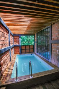 a swimming pool in a house with a brick wall at Covanro Sigiriya - Brand New Luxury Hotel in Sigiriya