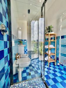 e bagno piastrellato blu con servizi igienici e doccia. di Zoroastrohome Borgo Peretola Firenze Nord a Firenze