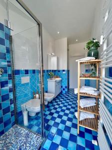 e bagno piastrellato blu con doccia e servizi igienici. di Zoroastrohome Borgo Peretola Firenze Nord a Firenze